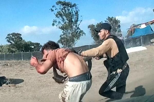 An armed Hamas fighter dragging a man during the Nova music festival attack.