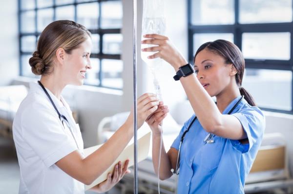Stock image of a doctor and nurse e<em></em>valuating an IV line. 