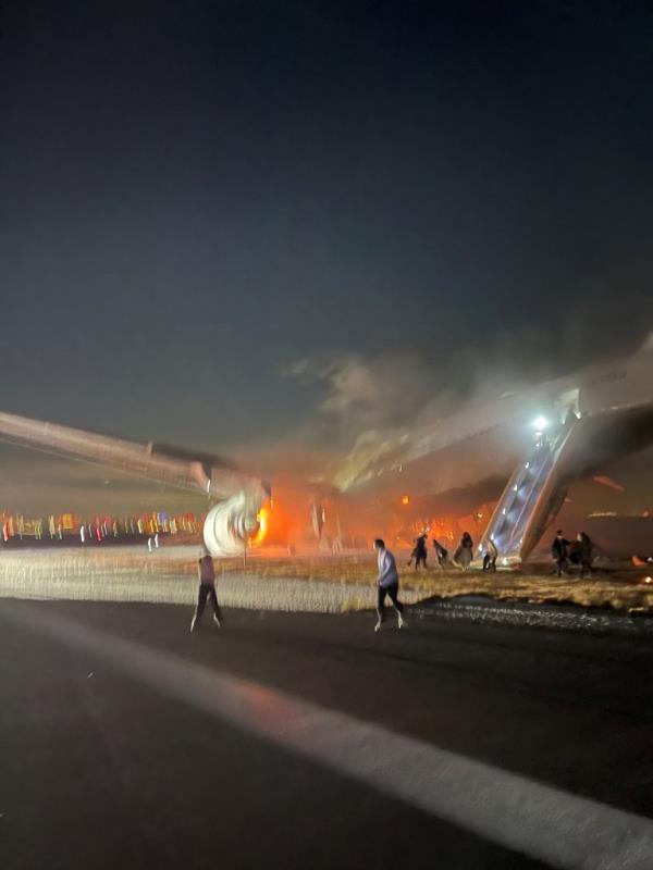 Passengers are seen escaping the plane.