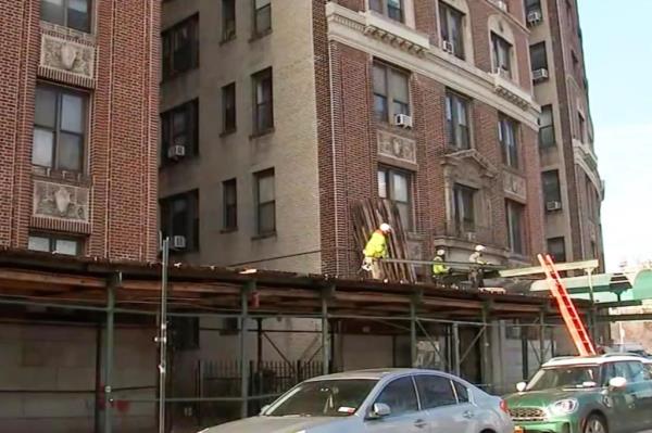 Three-week-old giraffe named Kendi, sits as his mother Katie