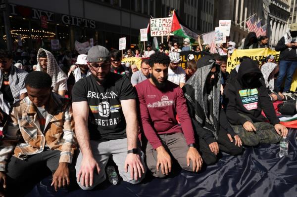 Pro-Palestinian demo<em></em>nstrators pray near Wall Street.